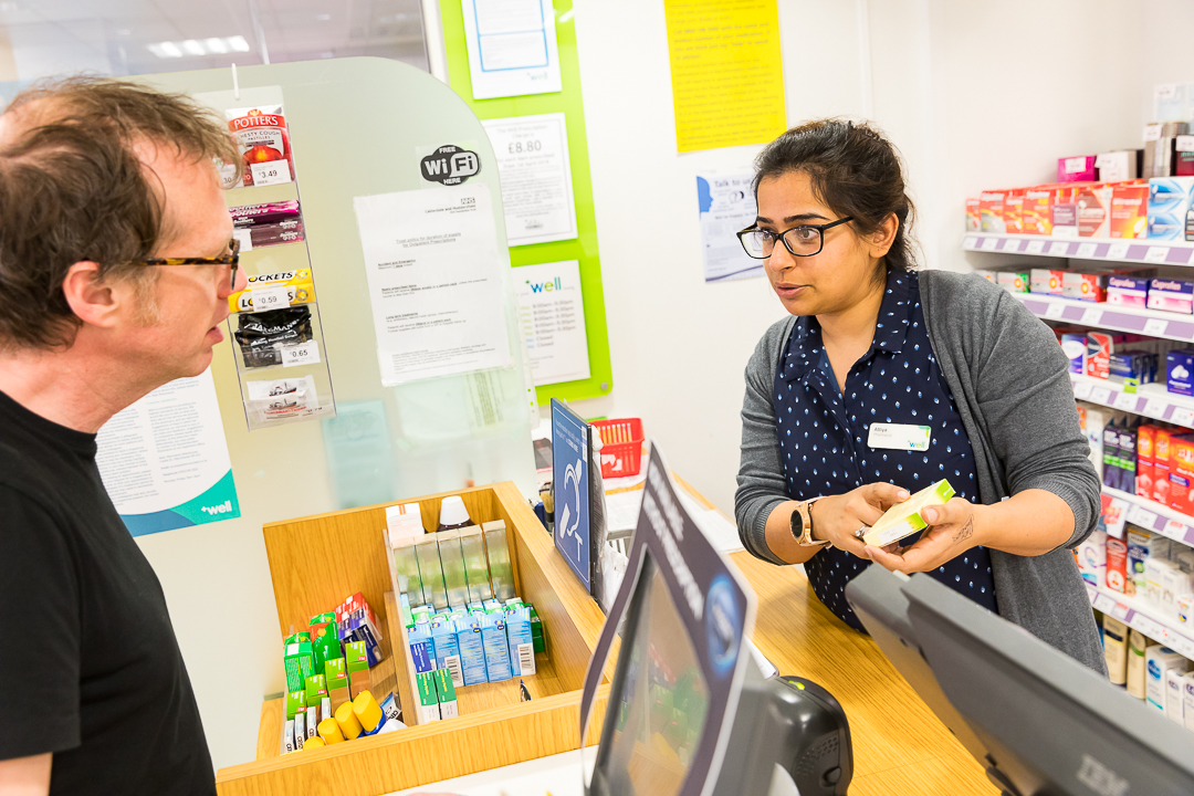 Pharmacist showing patient medication 