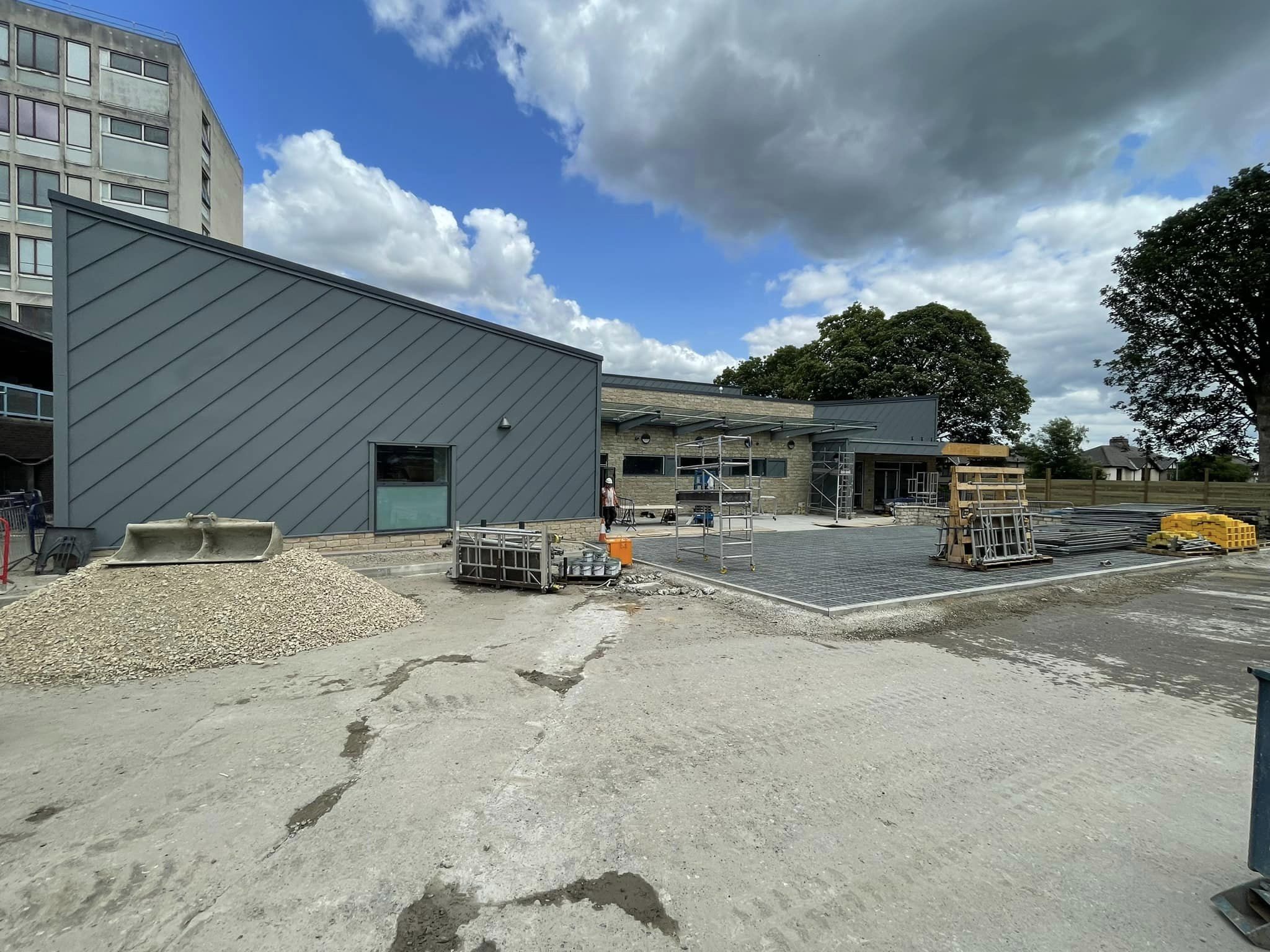 The exterior of the building, showing grey cladding and blue skies