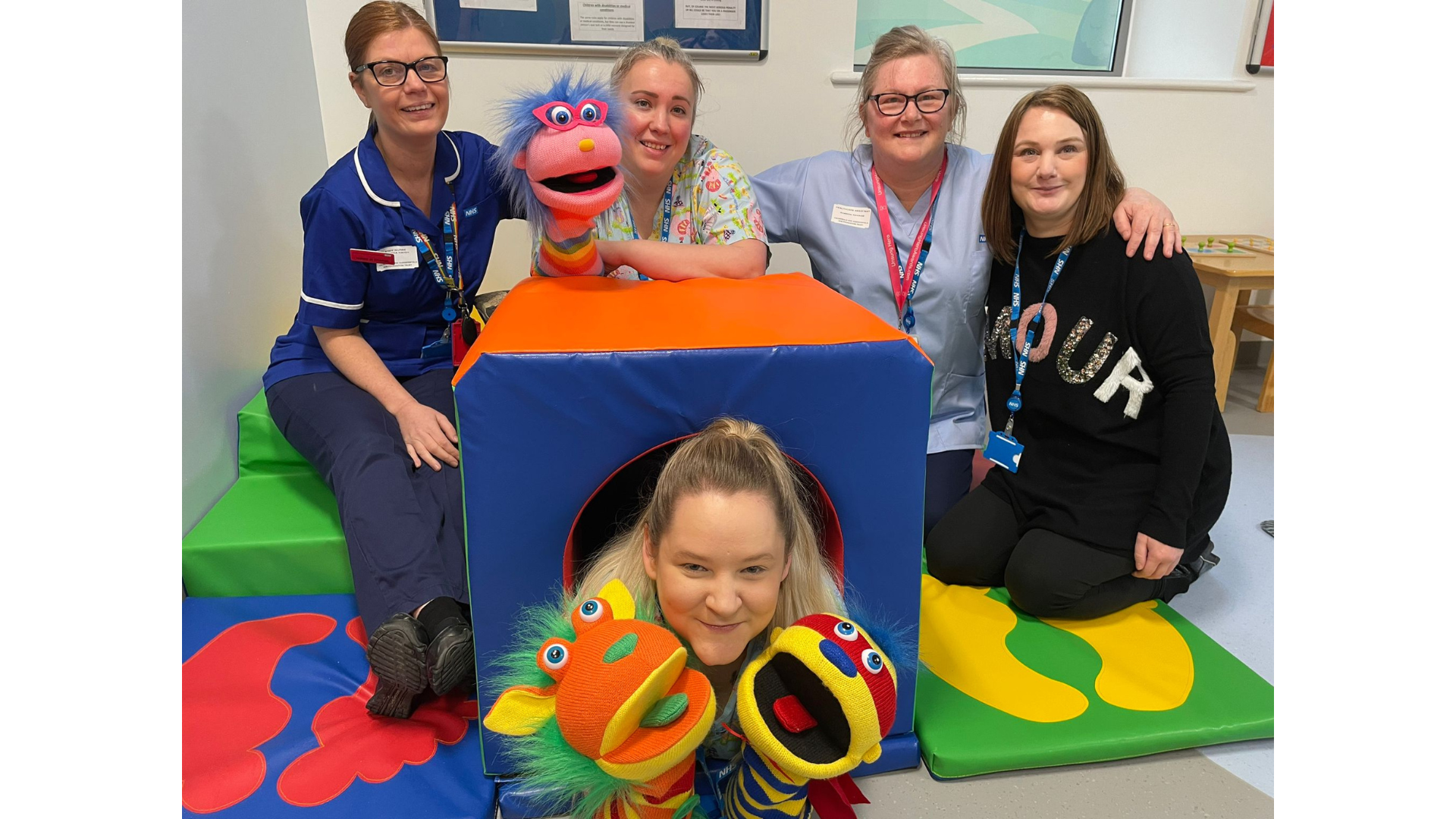 Some of our Rainbow colleagues posing with puppets