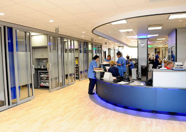 Numbered doors and nurses working at the nurses' bay.