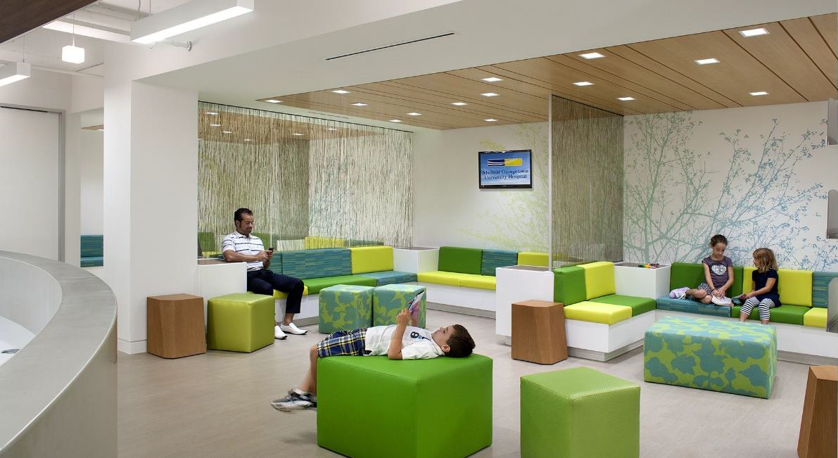 Well lit, colourful waiting area with patients waiting to be seen.