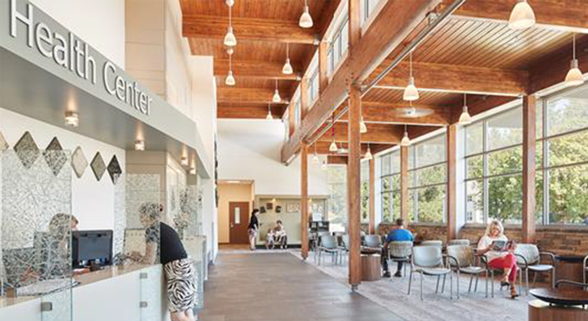 The health center with a check-in desk and a well-lit waiting area with large windows.