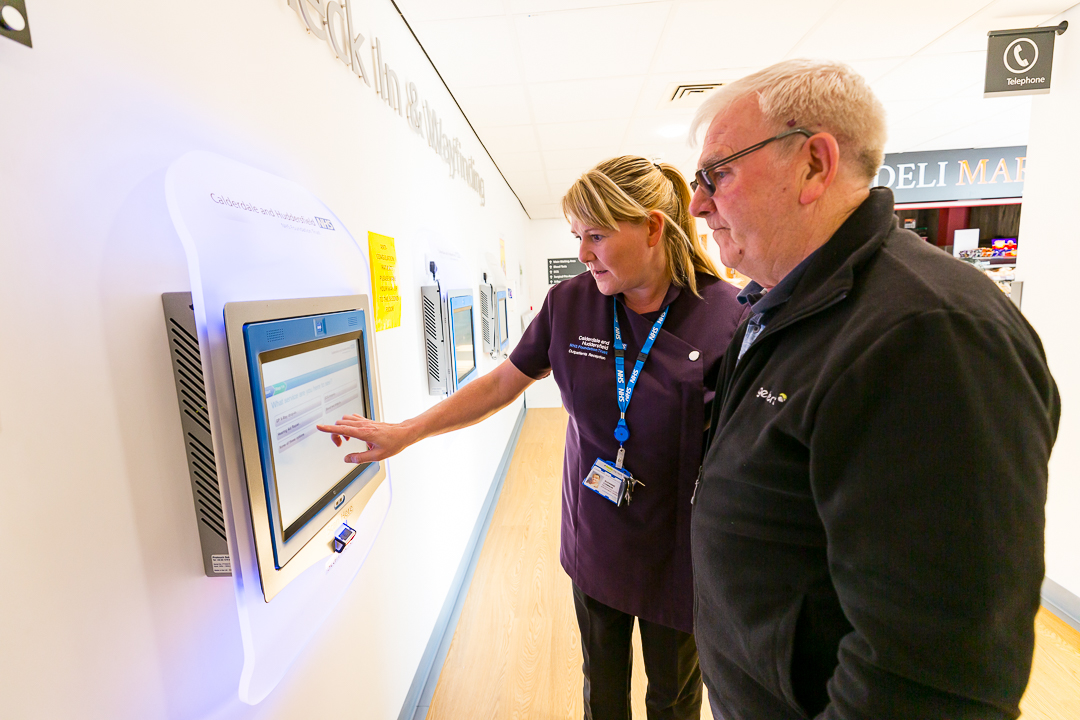 Nurse showing patient how to use self-check in screen