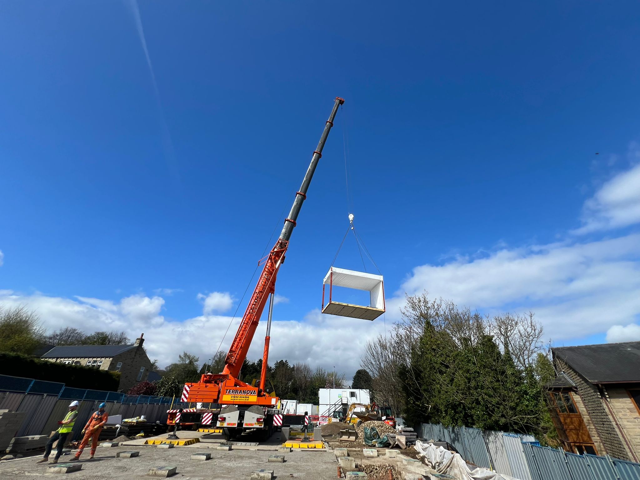 A crane lifts a section into place