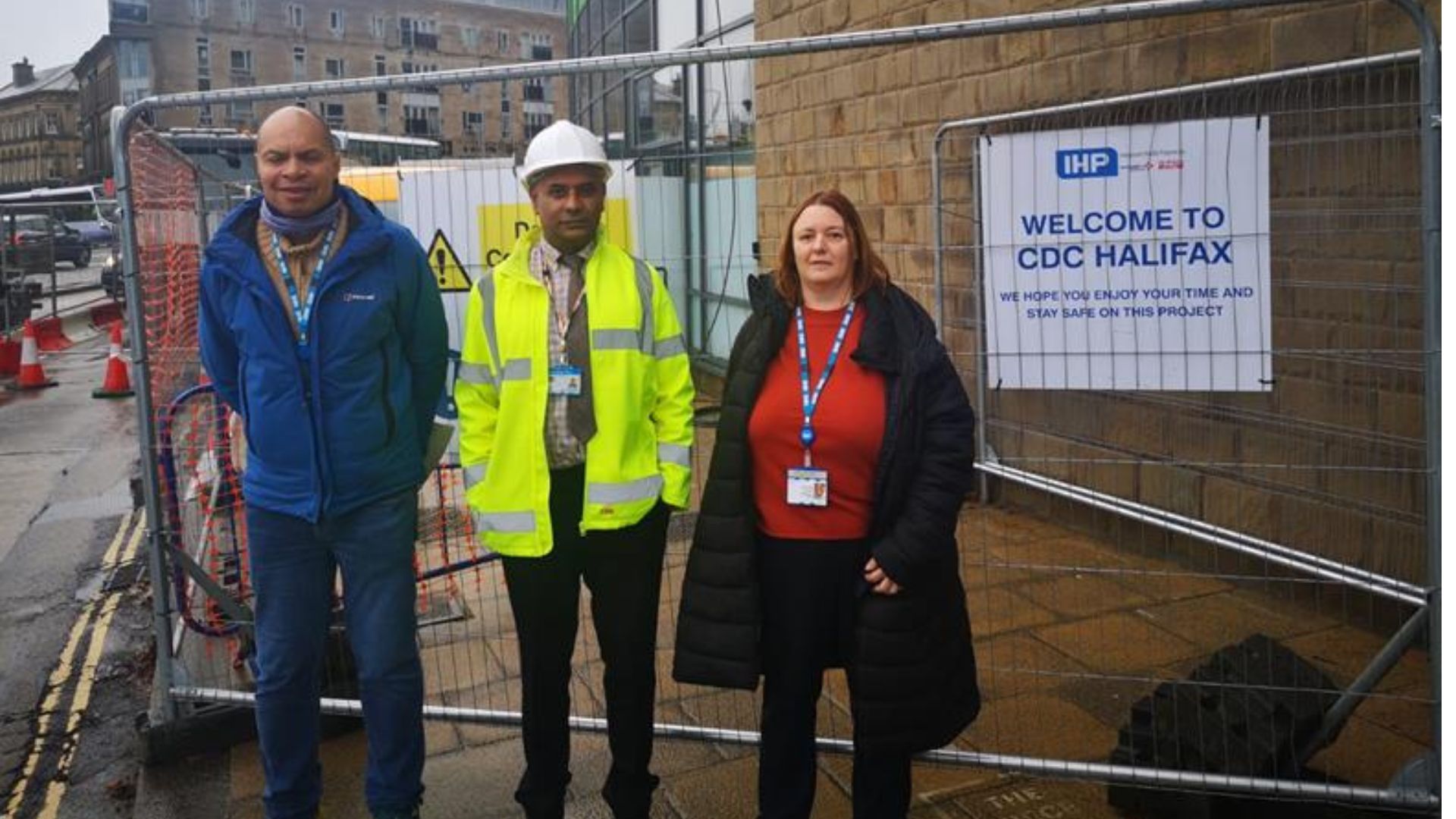 Pictured are Cleaning Services' Michael Hamilton, Estates Manager Jammal Mohammed and Ultrasound Service Lead Nicola Stephenson. They are standing in front of the hoardings for the construction site. 